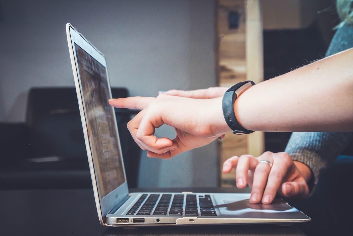 Two people reviewing content together on a laptop screen